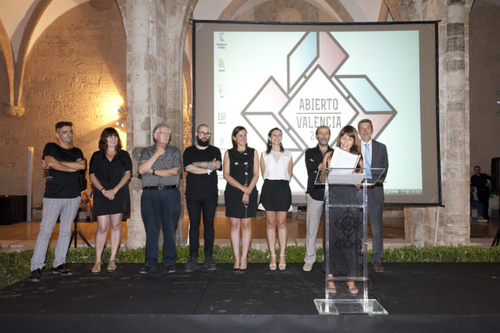 Reyes Martínez, secretaria de LaVAC, leyendo el comunicado de los premios. Detrás, de izquierda a derecha, Mira Bernabeu, Rosa Santos, Felipe Garín, Ismael Chappaz, María José Català, Olga Adelantado, José Gandía Blasco y Rafel Ripoll. Imagen cortesía de LaVAC.