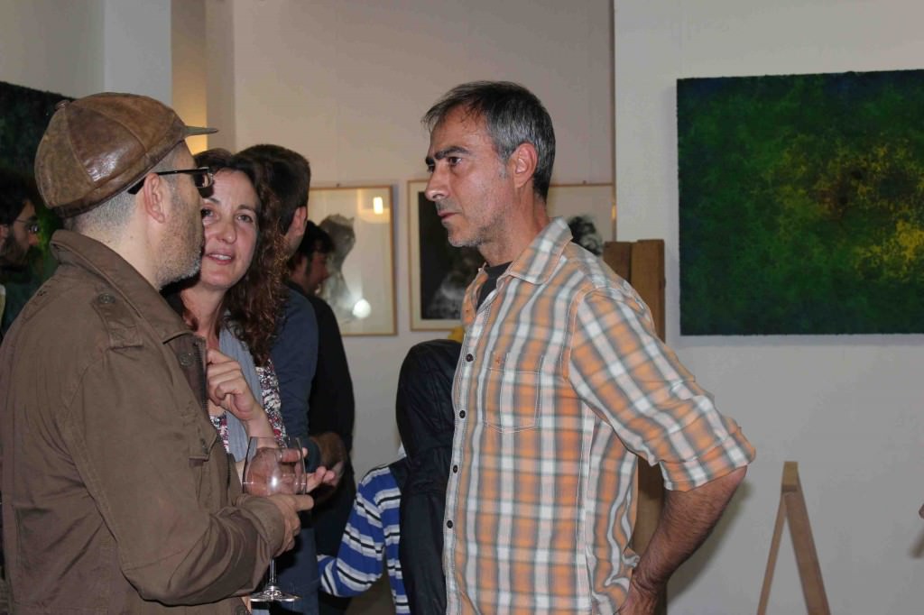El artista Iñaki Torres (camisa a cuadros) charla con algunos de los asistentes a su exposición en Espacio 40. 