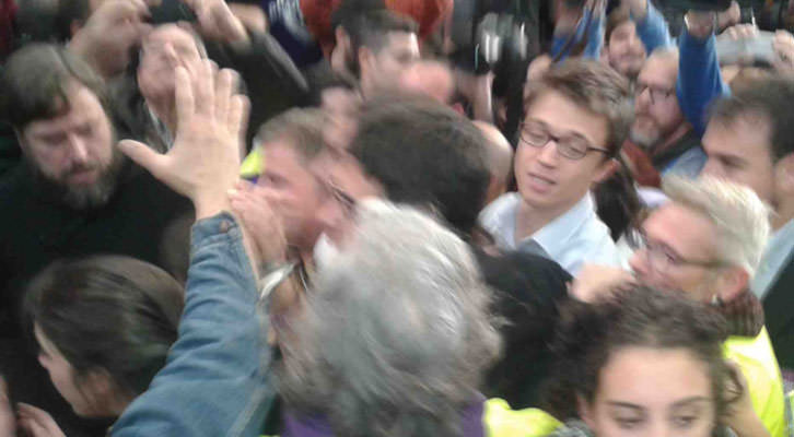 Iñigo Errejón, con gafas, abriéndose paso detrás de un tapado Pablo Iglesias, en el mitin de Valencia.