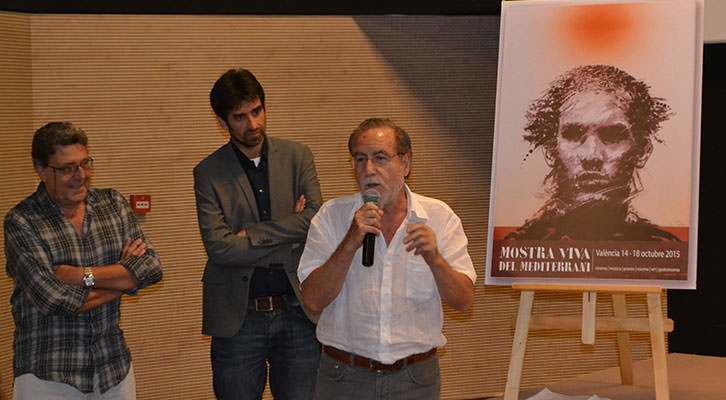 Manuel Boix, micrófono en mano, ante su cartel para Mostra Viva 2015, en presencia de Vicent Tamarit (izquierda) y José Luis Moreno (centro). Imagen cortesía de Filmoteca de CulturArts.