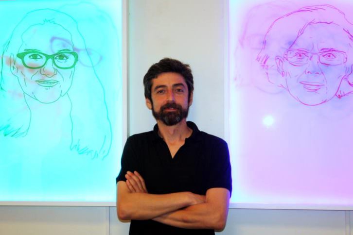 Javier Marisco ante sus obras LED de Mónica Oltra y Manuela Carmena, en la galería Alba Cabrera. Cortesía del autor.