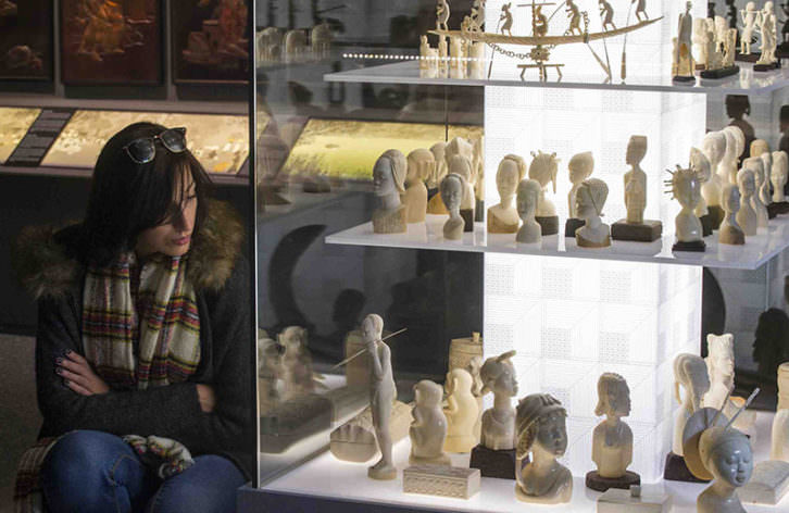 Una joven observa algunas de las pieza de la exposición Doctor Carsí, supongo? Fotografía de Raquel Abulaila cortesía del Museu Valencià d'Etnologia. 