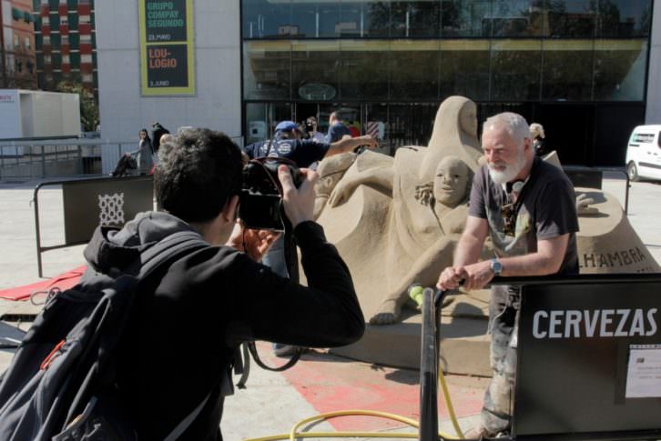 Dale Murdock junto a su escultura de arena. Imagen cortesía de Rambleta. 