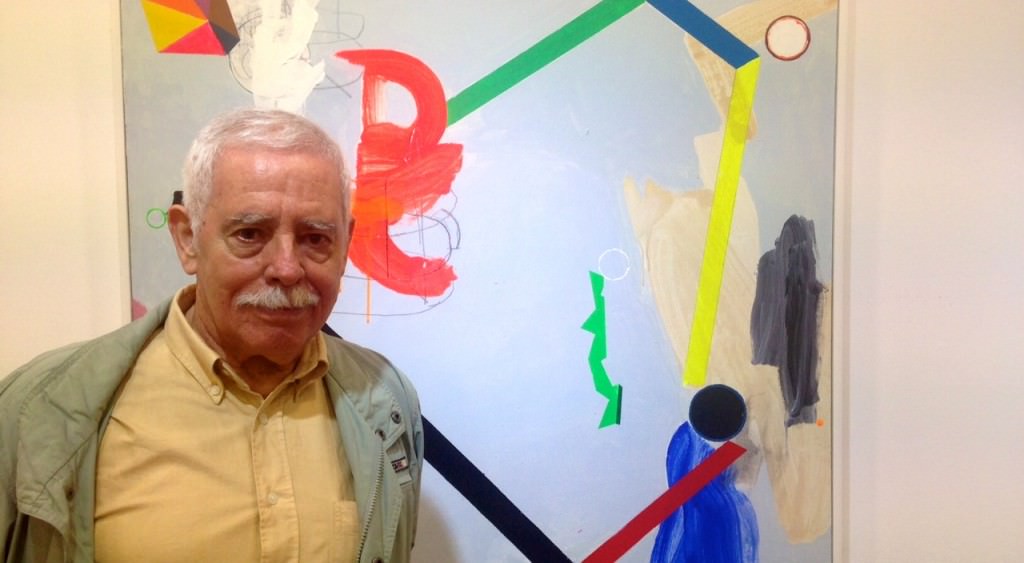 El artista Joaquín Capa delante de una de las obras pertenecientes a la exposición 'Colores abiertos', en Galería 9. Fotografía: Merche Medina.