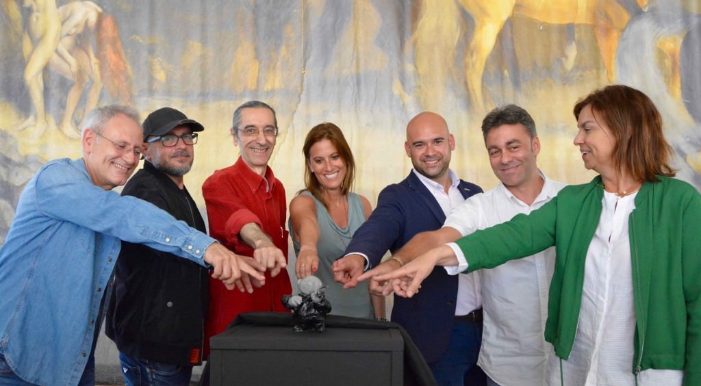 Miembros de la organización de la Semana Negra y representantes institucionales frente a la figura de Rufo, durante el encuentro con los medios celebrado en la Carpa del Encuentro. Fotografía: Merche Medina.