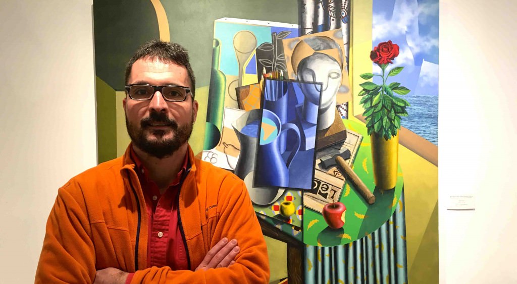 El artista Iván Araujo posa frente a la obra 'Bodegón Infinito XVI', presente en 'Todas las mañanas del mundo'. Fotografía: Merche Medina.