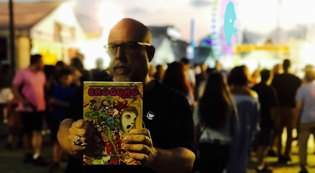 El escritor Jesús Palacios posa con un ejemplar de 'Eroguro. Horror y erotismo en la cultura popular japonesa', de Satori Ediciones, en plena XXXI Semana Negra de Gijón. Fotografía: Jose Ramón Alarcón.
