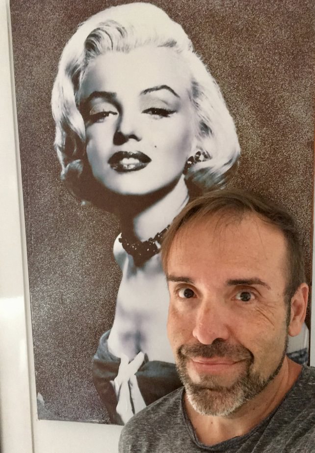 Javier Lacomba junto a un retrato de Marilyn Monroe. Imagen cortesía del autor.