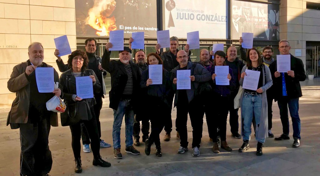 Diversos miembros de AVVAC muestran la misiva firmada por la presidenta de la Unión de Artistas Contemporáneos de España (UNIÓN_AC) a las puertas del IVAM. Fotografía cortesía de la asociación.