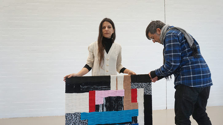 Azucena González junto a una de sus obras. Imagen cortesía de ART Mustang.