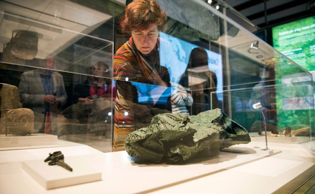 Una mujer contempla una de las obras de la exposición 'Galaicos. Un pobo entre dous mundos'. Foto de Abulaila por cortesía del Museu de Prehistòria de València.